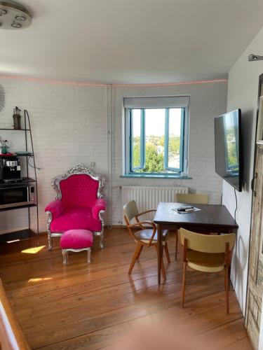a living room with a table and chairs at Torenkamer op de vijfde verdieping van de watertoren van Strijen in Strijen