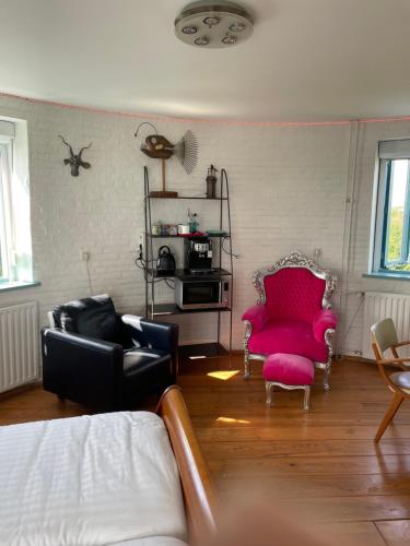 a living room with a couch and two chairs at Torenkamer op de vijfde verdieping van de watertoren van Strijen in Strijen