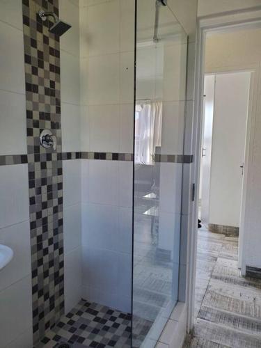 a bathroom with a shower with a glass door at Lovely apartment Back-up power in Sandton