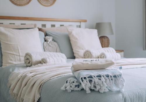 Una cama con mantas blancas y almohadas. en Joannes Retreat, Dog Friendly Property in Weymouth with Free Parking, en Weymouth