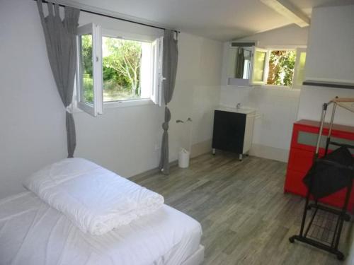 une chambre avec un lit blanc et une fenêtre dans l'établissement le pré en bulles gîte au milieu des vignes, à Euzet