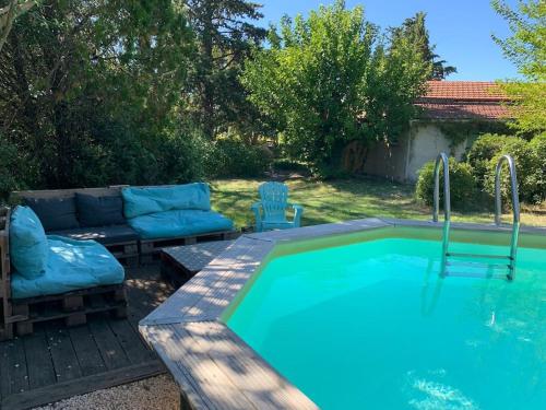 - une piscine dans une cour avec un canapé dans l'établissement le pré en bulles gîte au milieu des vignes, à Euzet