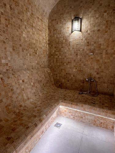 Cette chambre dispose d'une douche avec une lumière sur le mur. dans l'établissement AQ Capsule Hotel, à Almaty