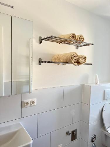ein weißes Badezimmer mit einem Spiegel und einem Waschbecken in der Unterkunft Gasthaus Sonnenblume in Salzburg