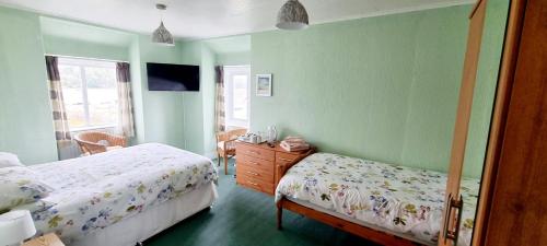a bedroom with two beds and a dresser at The Mariner Hotel in Kippford