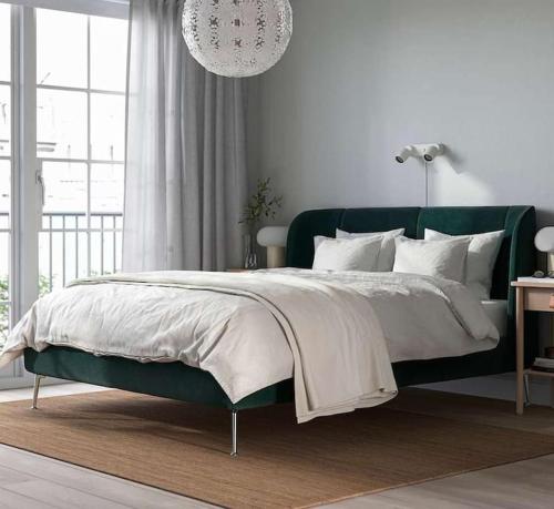 ein Schlafzimmer mit einem grünen Bett und einem Kronleuchter in der Unterkunft Designer Penthouse with Balcony in Wien
