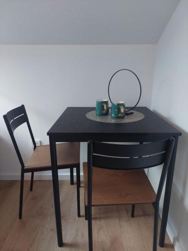 a black table and a chair with two mugs on it at COMFORT Suites VELIKA GORICA in Velika Gorica
