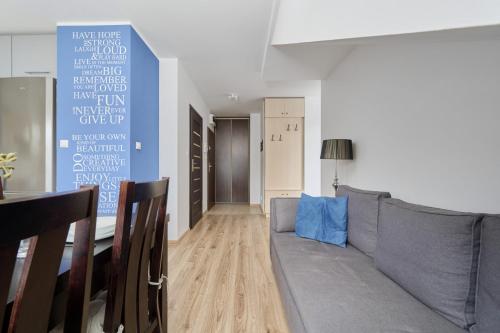 ein Wohnzimmer mit einem grauen Sofa und einem Tisch in der Unterkunft Comfortable & Cozy Studio with Balcony - Klimasa by Renters in Breslau