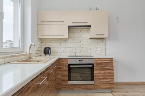 uma cozinha com armários brancos e um lavatório em Comfortable & Cozy Studio with Balcony - Klimasa by Renters em Breslávia