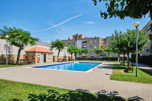 einen Pool in einem Park mit Bäumen und Gebäuden in der Unterkunft Dolce Barbera 15 min to Barcelona and beach in Barberà del Vallès