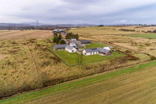 an aerial view of a house in the middle of a field at Architect Designed Lodge in Dunecht