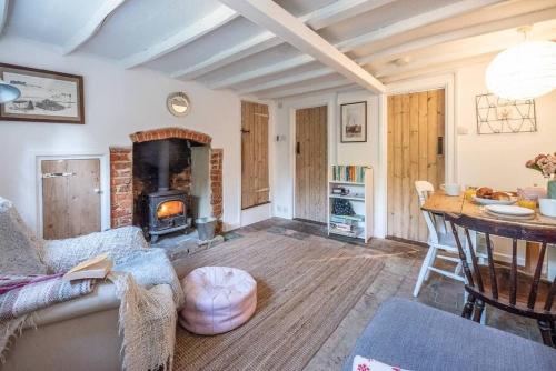 un salon avec un canapé et une cheminée dans l'établissement Lilac Cottage, Wenhaston, à Halesworth