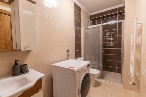 y baño con aseo, lavabo y ducha. en Stylish 2-bdr Apt 15 Min From Axis Istanbul Mall, en Estambul