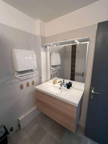 une salle de bain avec un lavabo et un miroir dans l'établissement Appartement 2 pièces à Juan, à Antibes