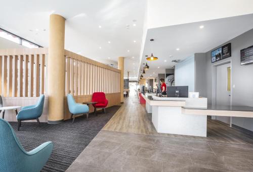 a lobby of a hospital with colorful chairs and desks at Ibis Mackay in Mackay