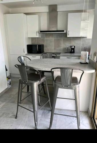 une cuisine avec une table et des chaises dans une cuisine dans l'établissement Appartement 2 pièces à Juan, à Antibes