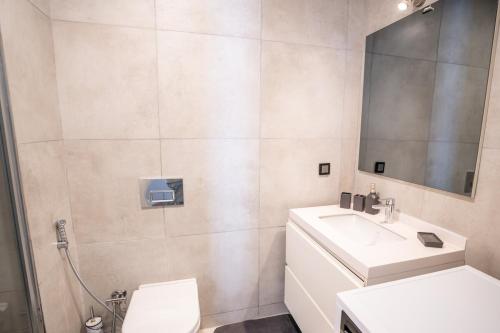 bagno con lavandino, servizi igienici e specchio di Stylish Retreat Cozy 2br Apt a Istanbul