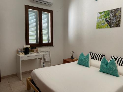 a bedroom with a bed with blue pillows and a desk at Agriturismo Pranu in Sorgono