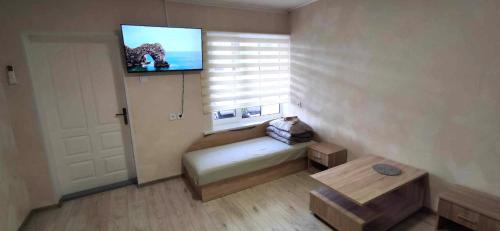 a small room with a bed and a tv on the wall at AGIRIJA 