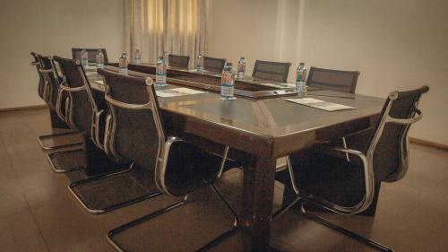 a conference room with a large wooden table and chairs at Hotel Marjorie `Y` in Tema