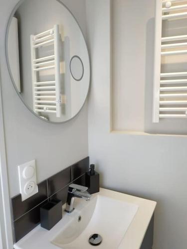 une salle de bain avec un lavabo blanc et un miroir dans l'établissement Cocoon - marché central, à La Rochelle