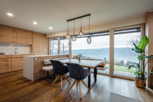 a kitchen with a table and chairs and a large window at Boutique Chalet - Herke in Eitweg