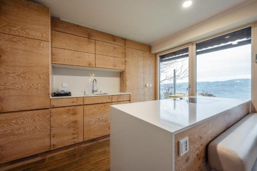 a kitchen with wooden walls and a large window at Boutique Chalet - Herke in Eitweg