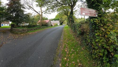 uma estrada com um sinal na lateral em Longford Holiday Yellow Star Self-Catering Cottage 