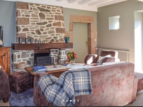 - un salon avec une cheminée en pierre et un canapé dans l'établissement La longère d'Adèle Gîte de charme avec jacuzzi, à Plouézec