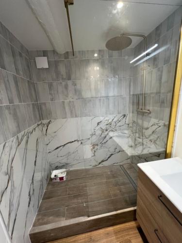 La salle de bains est pourvue d'une douche en marbre et d'un lavabo. dans l'établissement Appartement Gaillard, à Sanary-sur-Mer