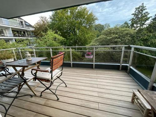 una terrazza in legno con tavolo e sedie sul balcone. di Ideale Unterkunft in Düsseldorf-Nord a Dusseldorf