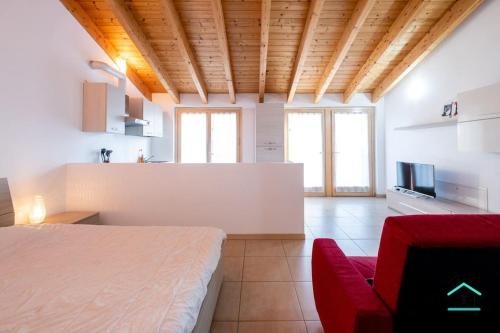 1 dormitorio con 1 cama y 1 sofá rojo en una habitación en Travedona Loft by lake Ixihome, en Travedona