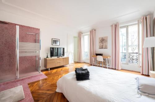 a white bedroom with a bed and a television at Luxury style appartement, Arc de Triomphe - Champs Elysées in Paris