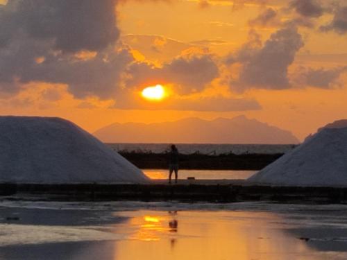 a person standing on the beach at sunset at B&B Le Macine 1868 in Paceco