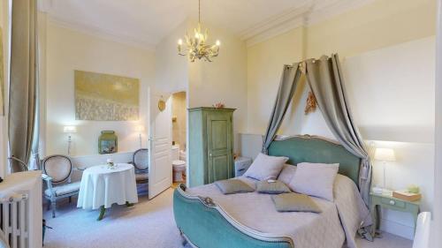 a bedroom with a bed and a table in it at Château "Le Castel des Anges" in Wailly-Beaucamp