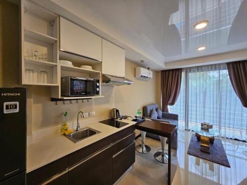 a kitchen with a sink and a table in it at Phuket Airport Hotel at Mai Khao Beach in Ban Bo Sai Klang