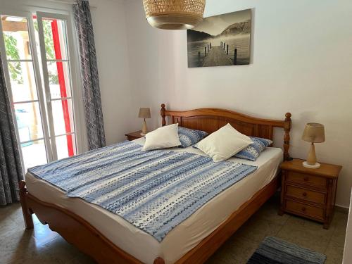 a bedroom with a bed with a blue and white comforter at Casa Lisboa in Cala Mesquida