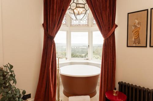baño con bañera y ventana en The Beacon en Royal Tunbridge Wells