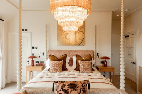 1 dormitorio con 1 cama grande y lámpara de araña en The Beacon en Royal Tunbridge Wells