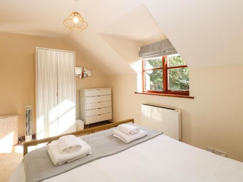 1 dormitorio con 1 cama con 2 toallas en Seaview Cottage en Holt