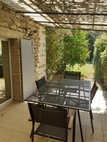 une table et des chaises en verre sur la terrasse dans l'établissement Cuisine, chambres et salle de bains indépendants, à Saint-Christol-lès-Alès