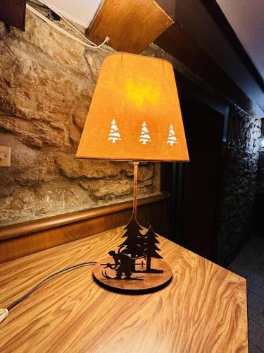 a lamp sitting on top of a wooden table at Auberge La Cléa in La Pesse