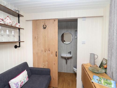 a living room with a couch and a sink at Hillside Hut in Ashbourne