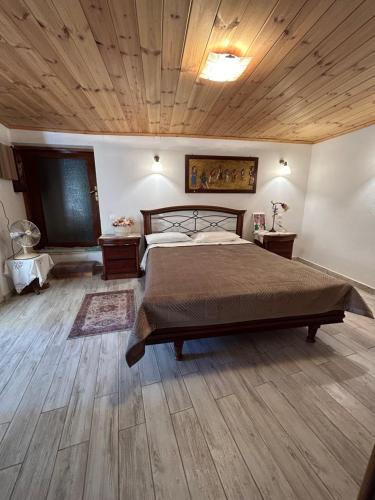 ein Schlafzimmer mit einem Bett und einer Holzdecke in der Unterkunft Tulip House in Yerakárion