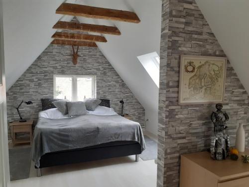 a bedroom with a bed in a brick wall at Ezzo guest house in Nakskov