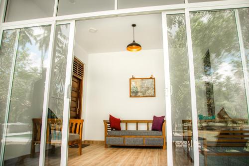 a living room with glass doors and a couch at CJ's House at Mawella in Mawella