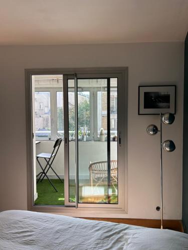 a bedroom with a sliding glass door to a patio at Superbe appartement au porte de Paris et du salon des expositions in Vanves