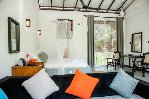 a living room with a couch and a bed at CJ's House at Mawella in Mawella