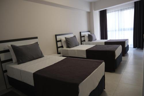 a hotel room with two beds and a window at JK BUSINESS HOTEL in Denizli