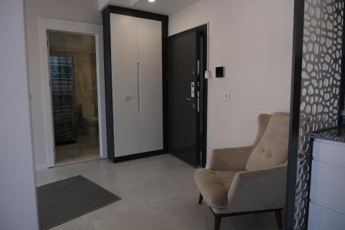 a living room with a chair and a mirror at JK Business in Denizli